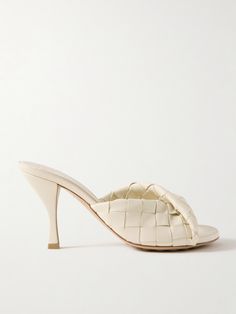 Bottega Veneta's 'Blink' mules are made using the label's iconic 'Intrecciato' technique which involves weaving strips of leather together, reinforcing the material and creating a unique finish. They have a gently twisted foot strap and fluted 85mm heels. Cream Sandals, Latest Sandal, Gucci Shop, Neutral Shoes, Raffia Bag, Bag Icon, Leather Mules, Pump Sandals, Metallic Leather