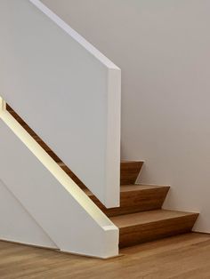 a white stair case next to a wooden floor