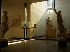 some statues in a room with sunlight coming through the window