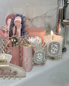 the bathroom counter is filled with pink and white items, such as toothbrushes