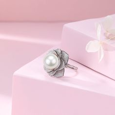 This elegant ring features a stunning 11-12mm white freshwater pearl accented by a brilliant 11-12mm Miya zirconia flower. The open closure design adds a modern touch to this timeless piece. Expertly crafted, this ring is a must-have for any pearl lover's collection. Material: 925 Sterling Silver, 4A freshwater pearl, and cubic zirconia Flexible size with open closure Elegant Cubic Zirconia Flower Ring, Elegant Silver Flower Ring With Diamonds, Elegant White Gold Flower Ring With Cubic Zirconia, Elegant White Flower Ring, Elegant White Flower Shaped Ring, Elegant White Flower Shape Ring, Elegant White Flower-shaped Ring, Elegant Sterling Silver Flower Ring, Elegant Silver Flower Shaped Ring