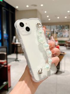 a person holding up a phone case with beads on it