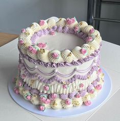 there is a large cake that has been decorated with pink and purple flowers on it