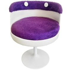 a purple and white chair sitting on top of a table