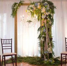 a wedding ceremony setup with flowers and greenery