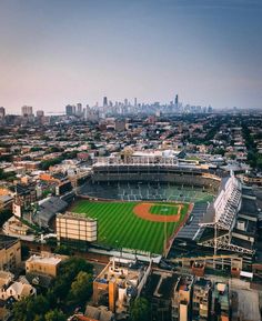 an aerial view of a baseball stadium and the cityscape in the back ground