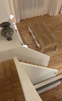 an aerial view of a dining table and chairs in a living room with wood flooring