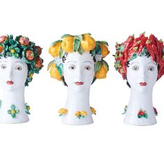 three ceramic heads with fruit and vegetables on them, one is wearing a flowered hat