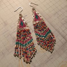 Stunning long metallic handmade seed earrings made with super bright square silver seed beads with pink, turquoise and soft matte pastel multicolored 11/0 seed beads. The earrings have long flowing fringe. The french hook earwires and findings are sterling silver. These gorgeous Cheyenne style earrings are super long and brush your shoulders ever so slightly. Great for daywear and stunningly beautiful for the night out. Earrings measure approximately 3-1/2 inches including ear wires. All items a Bead Work Jewelry, Beaded Hoop Earrings, Pink Turquoise, Seed Bead Earrings, Large Earrings, Fringe Earrings, Bead Earrings, Earrings Silver, Chandelier Earrings