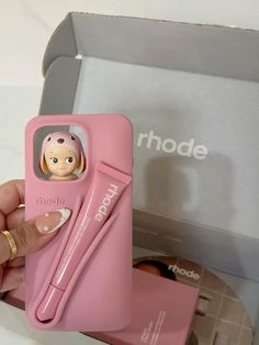 a pink phone case with a doll in it