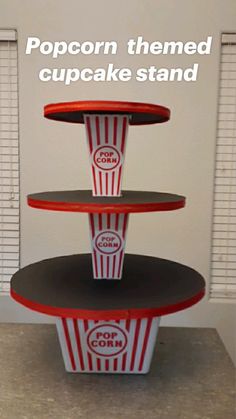 three tiered cupcake stand with popcorn on top and the words popcorn themed cupcake stand above it