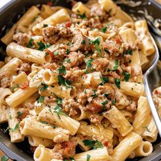 a bowl full of pasta with meat and parsley