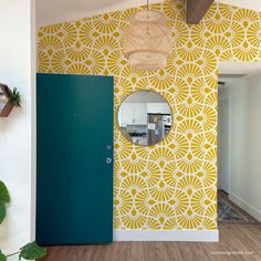 a yellow and white wall with a mirror hanging on it's side next to a green door