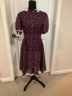 This nice vintage 70s 80s Plum floral Cottage Core calico print lace collar dress with ties in back comes to you in a short sleeve style and buttons up the front. No tag inside the dress and seems to be somewhat sheer as you can see from pictures. Short Sleeve Dresses With Ditsy Floral Print For Daywear, Fitted Short Sleeve Prairie Dress For Daywear, Vintage Short Sleeve Floral Dress, Retro Spring Prairie Dress With Short Sleeves, Fitted Short Sleeve Prairie Dress In Cottagecore Style, Vintage Mid-length Dresses For Garden Party, Summer Vintage Dress With Lace Trim, Vintage Mid-length Dresses For Daywear, Vintage Midi Dress For Casual Occasions