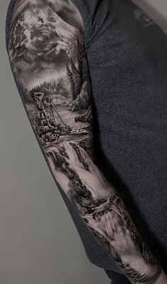 a man's arm covered in black and grey ink with mountains, trees and clouds