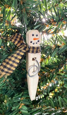 a wooden ornament hanging from a tree with a ribbon around it's neck