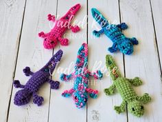 four crocheted alligators sitting on top of a white wooden floor next to each other