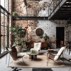 a living room filled with furniture and lots of plants on top of a wooden floor