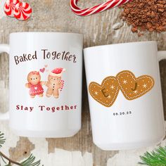 two coffee mugs sitting next to each other on top of a wooden table with candy cane