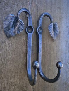 a metal hook on the side of a wooden door with two leaves attached to it