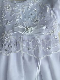 Details Amazingly elegant christening gown of embroidered tulle has beaded accents throughout. Ribbon bow at bodice and petite bows on each cap sleeve. Bottom of skirt has a scalloped trim. Includes a matching bonnet to complete the look. Sizes Available: X-Small (0-3 Months), Small (3-6 Months), Medium (6-12 Months), and Large (12-18 Months) Made in the USA by Lito Childrens Wear. Dry Clean only. Elegant First Communion Dress With Fitted Bodice, Elegant First Communion Dress With Short Sleeves, Embroidered Tulle Dress For Ceremonies, Elegant Short Sleeve First Communion Dress With Fitted Bodice, Elegant Short Sleeve Tulle Baptism Dress, Fitted Tulle Baptism Dress With Bow, Organza Baptism Dress With Lace Bodice For First Communion, Elegant Tulle Baptism Dress For Ceremony, Ceremony Embellished Tulle Dresses