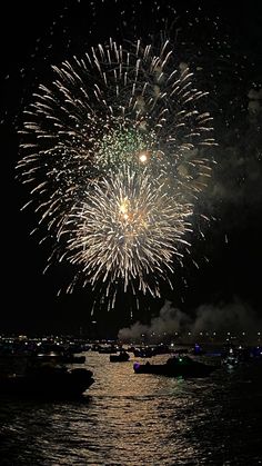 fireworks are lit up in the night sky over water