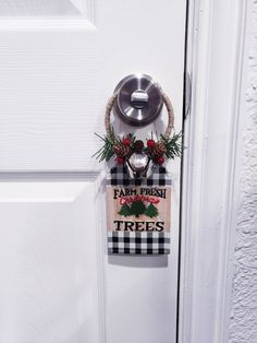 a door hanger that says, farm fresh trees and pine cones hanging on the front door