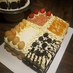 there is a large cake with different toppings on the top and bottom layer, along with other desserts