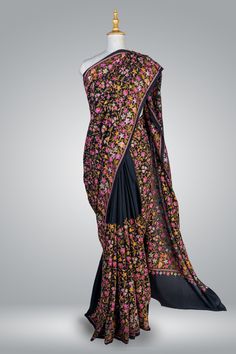 Black Crepe Saree All Over Embroidered, Elegant Women Saree With Aari Embroidery, Party Wear Saree Immerse yourself in the rich heritage of Kashmiri craftsmanship with this exquisite Chinar Pure Crepe Saree adorned with intricate hand aari embroidery. The luxurious black crepe fabric serves as a canvas for the exceptional artistry of the skilled artisans of Kashmir, who dedicate countless hours to create the breathtakingly beautiful motifs adorning this saree. The centerpiece of this saree is the heavy multicolour aari hand embroidery along the border and the pallu, showcasing the iconic Chinar design. The Chinar, or maple leaf, holds a deep cultural significance in Kashmir, representing the region's captivating natural beauty and storied history. The harmonious blend of green, red, and br Traditional Salwar Kameez With Multicolor Embroidery For Reception, Unstitched Traditional Wear For Reception With Multicolor Embroidery, Anarkali Jamawar Saree For Reception, Jamawar Anarkali Saree For Reception, Transitional Pre-draped Saree With Floral Embroidery, Traditional Drape Salwar Kameez With Multicolor Embroidery For Reception, Traditional Wear With Floral Embroidery On Georgette, Unstitched Floral Embroidered Saree In Traditional Drape, Traditional Designer Saree With Floral Embroidery