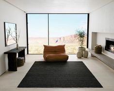 a living room filled with furniture and a large window overlooking the mountains in front of it