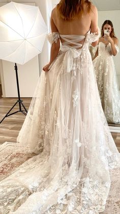 a woman in a wedding dress is taking a selfie with her cell phone as she stands in front of a mirror