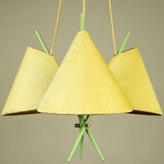 three yellow lamps with green sticks sticking out of the bottom and one light on each side