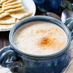 there is a bowl of soup with crackers on the side