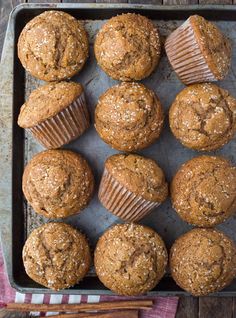 freshly baked muffins on a baking tray with cinnamon sticks