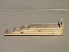 a wooden bench sitting on top of a cement ground