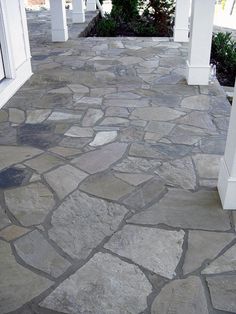 a stone walkway between two white pillars