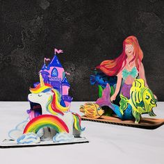 two paper cutouts of mermaids and unicorns sitting on top of each other