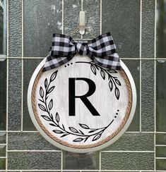 a wooden sign hanging on the side of a building with a ribbon around it's letter