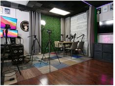 the room is decorated with green wallpaper and wooden flooring, along with several cameras