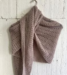 a knitted shawl hanging from a hook