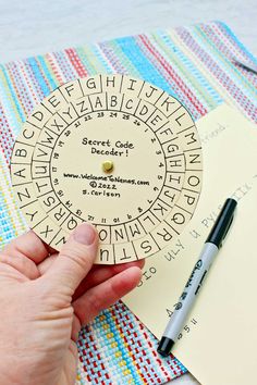 a hand holding a paper wheel with writing on it next to a notepad and pen