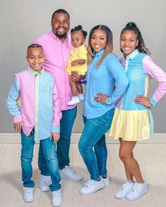 a family posing for a photo in front of a wall