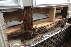 an old window with some wood on the outside and inside, in front of a house