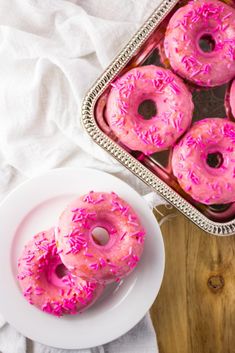 pink donuts with sprinkles on a white plate