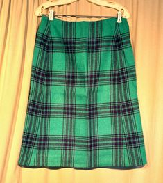 This is a cute vintage wool skirt, from the 70s. Labeled Real Shetland Tweed, All Wool-Woven in Scotland Exclusively for Deans. Tagged a size 16. Waist measures 32", please see measurements.  Made of 100% wool in a bright grass green ( brighter than the photos show) & black plaid pattern.  It is an A-Line skirt, that reaches to below the knee. Zips in the back with a nylon zipper, along with a button & tab at the waistband. Skirt is fully lined.   The skirt is in very good condition. No soil or stains.  No holes or tears. No moth nibbles. No fading. Sweet! Measurements were taken with the garment lying flat. If you have never worn vintage before, please measure yourself!! Will fit best if your measurements are a little smaller than the measurements given. If you have any questions about me Retro Green Skirt For Fall, Retro Wool Skirt For Fall, Vintage Pencil Skirt For Fall, Retro Wool Skirt For Winter, Vintage Wool Lined Skirt, Vintage Plaid Skirt For Work, Vintage Wool Skirt, Seventies Fashion, Grass Green