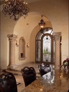 an elegant dining room with marble counter tops and chandelier