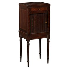 an old wooden cabinet with two legs and a drawer on one side, the door is open