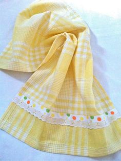 a yellow and white checkered scarf laying on top of a bed