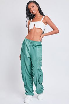 It’s giving off-duty vibes! Our Women's High-Rise Rouched Nylon Jogger is the perfect baggy pant to add to your wardrobe! Designed with an adjustable bungee cord at the elasticized waistband for the perfect fit and comfort. These high waisted pants are meant to be oversized with a baggy and slouchy fit. Featuring silver hardware and large cargo pockets for a sporty-chic vibe. We’ve also added adjustable bungee cords at the bottom hems to give you the option of wearing them more scrunched up at the ankle. Pair these with a crop top and sneakers for a sporty look, or pair with a corset top and combat boots for an edgier feel. Product Details - High-Rise - Elasticized Waistband with Bungee- Single Zip Close Pocket at Thigh- 2 Flap Cargo Pockets at Lower Side - Baggy Fit - Drawstring Hems Size Summer Utility Parachute Pants For Outdoor Activities, Athleisure Parachute Pants For Spring Outdoor Activities, Sporty Parachute Pants For Summer Outdoor, Spring Athleisure Parachute Pants For Outdoor, Sporty Summer Parachute Pants For Outdoor, Sporty Cargo Pants With Drawstring For Summer, Spring Athleisure Parachute Pants For Outdoor Activities, Green Nylon Parachute Pants Athleisure, Green Nylon Parachute Pants For Athleisure