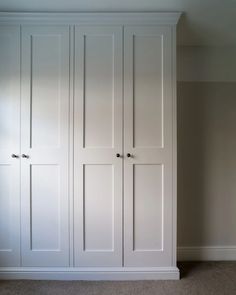 an empty room with white closets and carpeted flooring on the side walk in closet